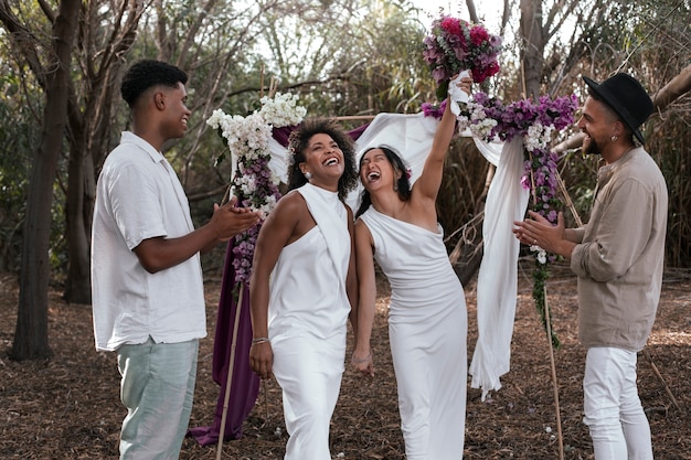 Foto gratuita una coppia lesbica che celebra il giorno del loro matrimonio con ospiti e amici