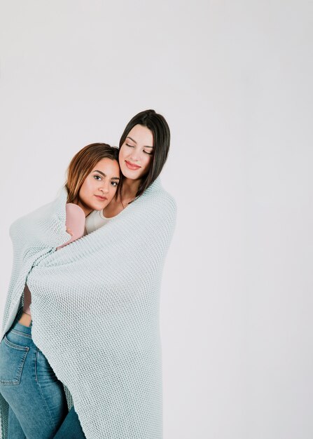 Lesbian couple in cozy blanket