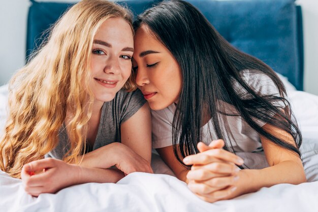 Lesbian couple cuddling in bed