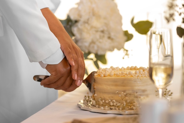 Free photo lesbian couple cutting the cake at their wedding