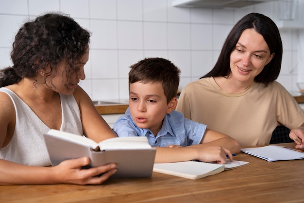 Lesbian couple helping their son to do his homework