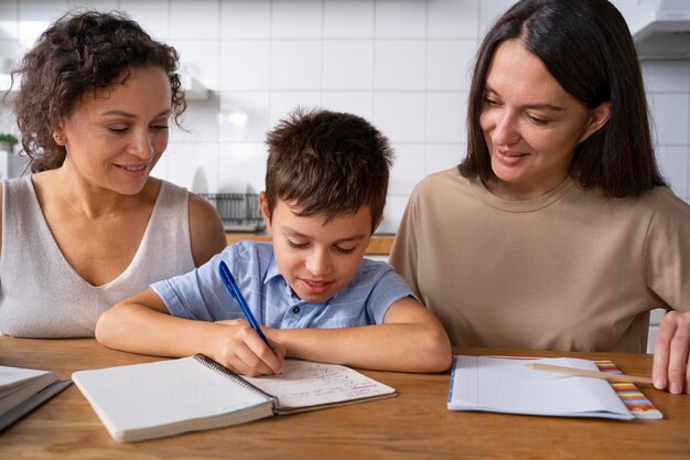 Lesbian couple helping their son to do his homework