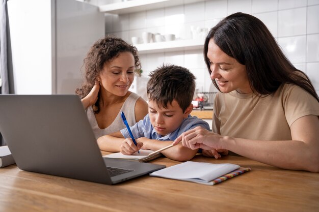 Lesbian couple helping their son to do his homework