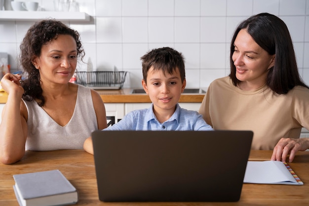 Lesbian couple helping their son to do his homework