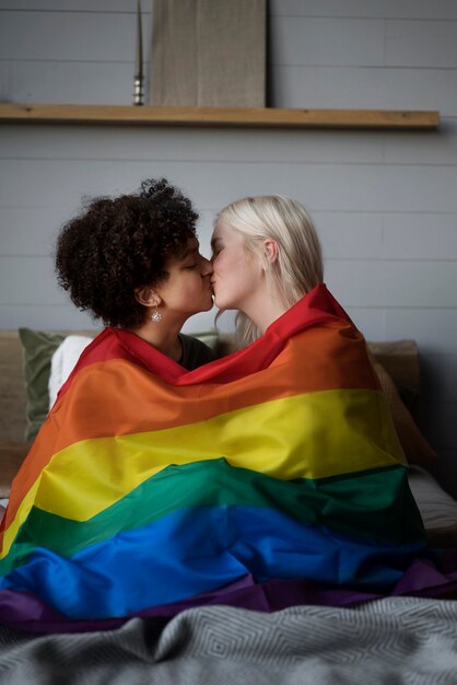 LGBTの旗とレズビアンのカップルのキス