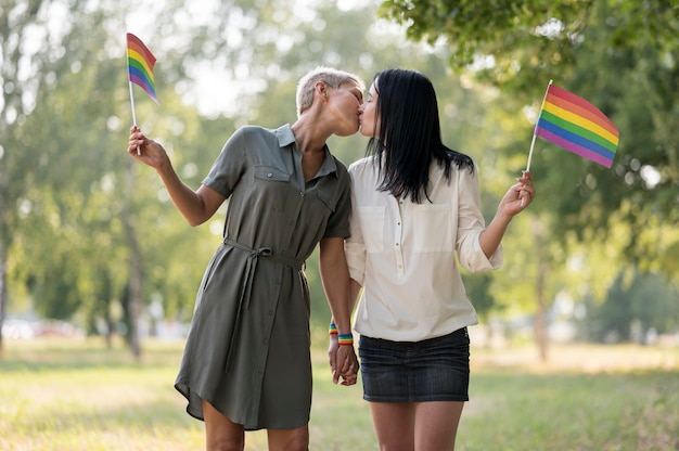 Lesbian couple kissing and holding flag