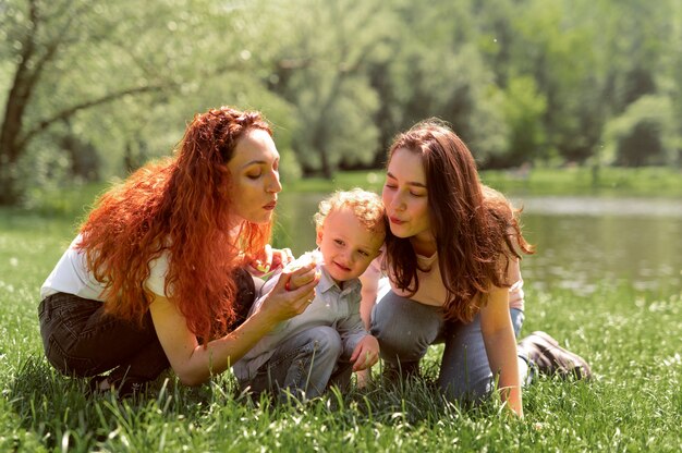 Lesbian couple spending time with their kid in the park