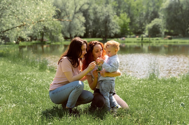 Foto gratuita coppia lesbica che trascorre del tempo con il figlio nel parco