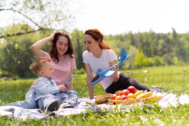 Lesbian couple spending time with their kid in the park