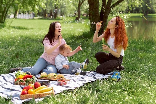 Free photo lesbian couple spending time with their kid