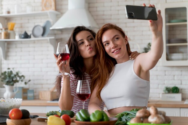 Lesbian couple taking a selfie in their kitchen