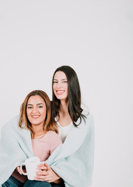 Lesbian couple with mug in plaid