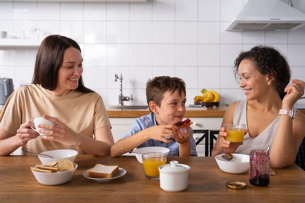 Lesbian couple with their son eating breakfast