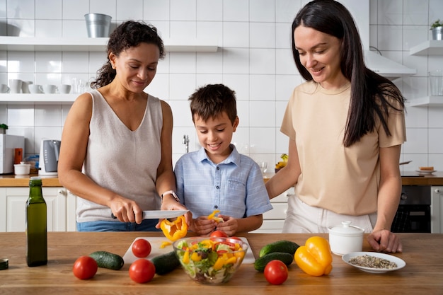 Lesbian couple with their son preparing some food