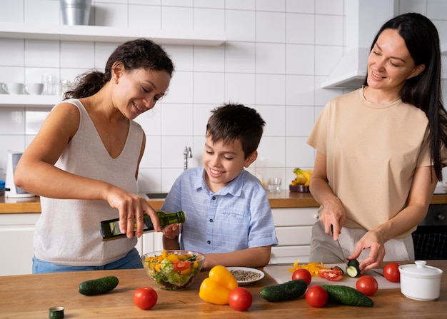 いくつかの食べ物を準備している彼らの息子とのレズビアンのカップル