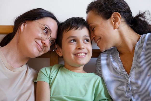 Free photo lesbian couple with their son spending time together at home