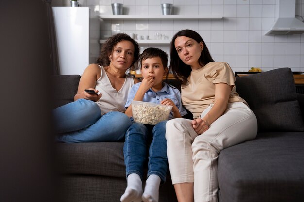 Lesbian couple with their son watching a movie