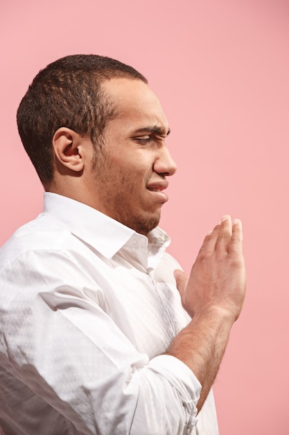 Free photo let me think. doubtful pensive man with thoughtful expression making choice against pink