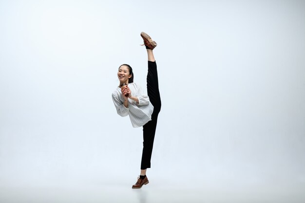 Let's start with aroma coffee. Happy woman working at office, jumping and dancing in casual clothes or suit isolated on white studio background. Business, start-up, working open-space concept.