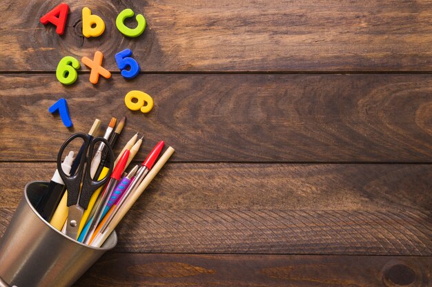 Letters and numbers near cup with stationery