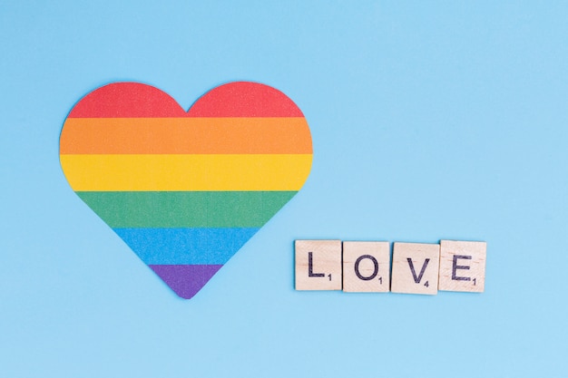 Значок сердца ЛГБТ и слово любовь на деревянных блоках
