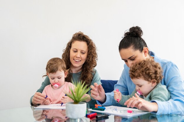Lgbt mothers at home drawing with their children