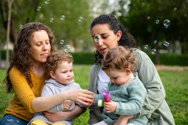 Lgbt mothers outdoors in the park with their kids