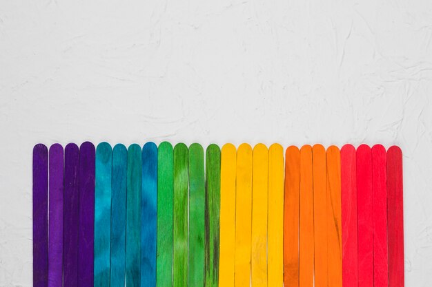 LGBT rainbow of colorful wooden sticks on grey surface