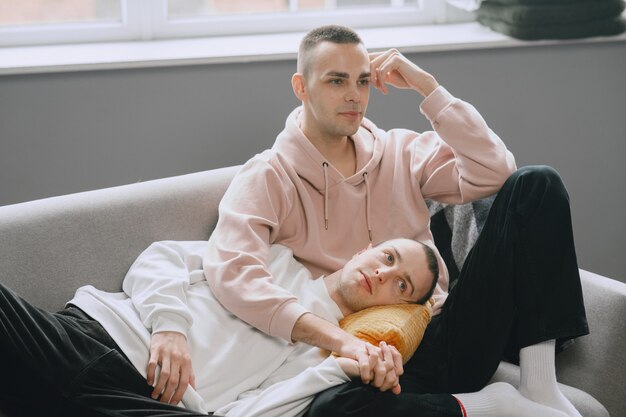 Lgbtq couple relaxing on the couch. Different family lifestyle concept.