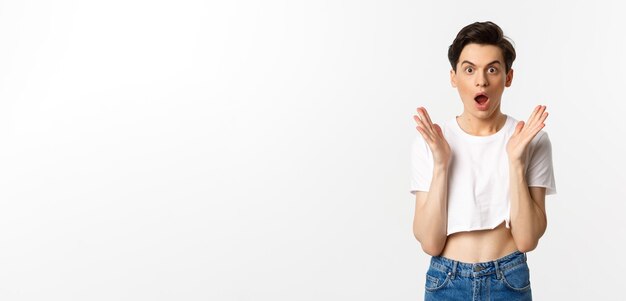 Lgbtq and pride concept image of surprised queer guy clap hands and looking in awe at camera standin