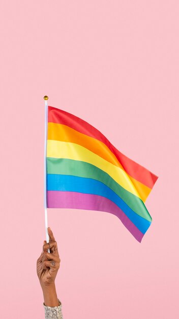 LGBTQ+ pride flag with woman&amp;rsquo;s hand raising