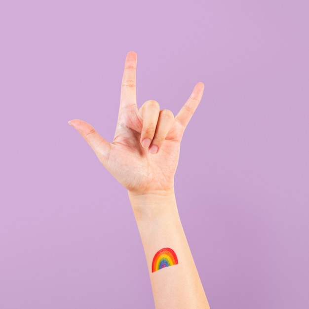 Foto gratuita tatuaggio orgoglio lgbtq+ con rock n' rotolare la mano in aria