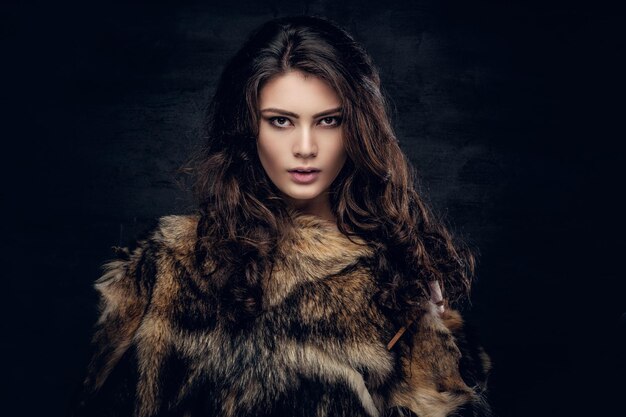 Libidinous brunette female with long curly hair dressed in a fur coat.