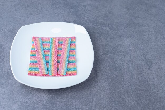 Licorice candy on a plate on marble table.