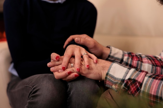 Free photo life partners holding hands at couple therapy session with counseling specialist, enjoying reconciliation after marriage issues. solving relationship problems with professional help. close up.