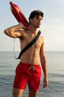 Free photo lifeguard holding lifesaving buoy side view