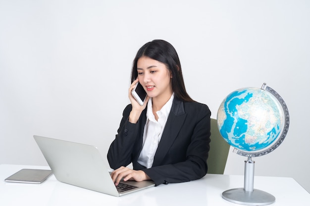 라이프 스타일 아름다운 아시아 비즈니스 젊은 여자가 사무실 책상에 랩톱 컴퓨터와 스마트 폰을 사용