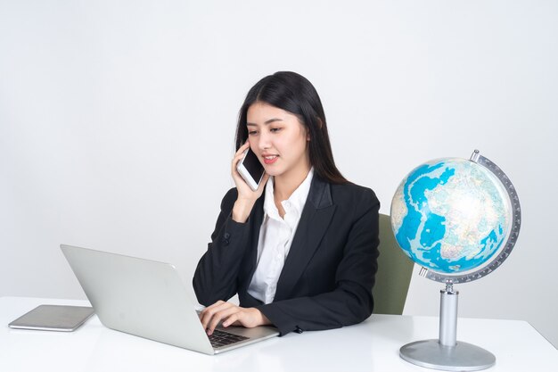 lifestyle beautiful Asian business young woman using laptop computer and smart phone on office desk 