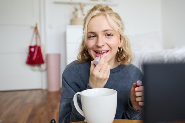 Lifestyle beauty blogger woman recording video of her putting on makeup talking to camera making