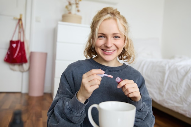 Lifestyle beauty blogger woman recording video of her putting on makeup talking to camera making