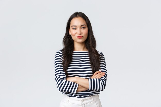 Lifestyle, beauty and fashion, people emotions concept. Skeptical and judgemental asian female office manager looking picky, smirk and pouting dissatisfied, cross arms chest