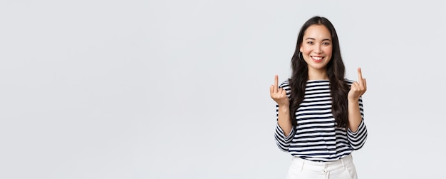 Free photo lifestyle beauty and fashion people emotions concept unbothered and careless young happy smiling woman dont give a damn showing middle fingers and feeling good white background