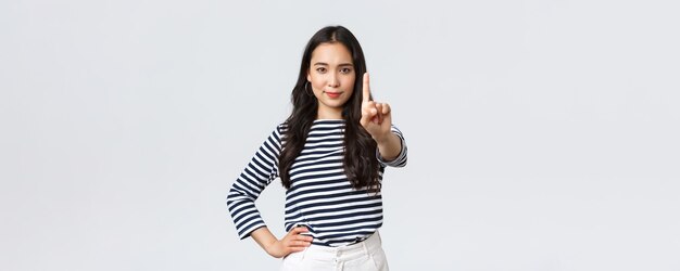 Lifestyle beauty and fashion people emotions concept Wait a sec Seriouslooking confident asian woman scolding someone shaking index finger to prohibit or disapprove action