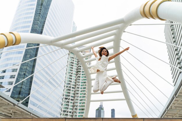 ライフスタイルビジネスの女性は、成功を祝う空気で幸せなジャンプを感じる