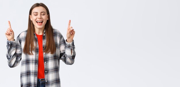 ライフスタイルのさまざまな感情レジャー活動のコンセプトチェックシャツの夢の夢のような幸せなかわいい若い女性が実現しました夏休みのリゾートが目を閉じて指を指していることを示しています