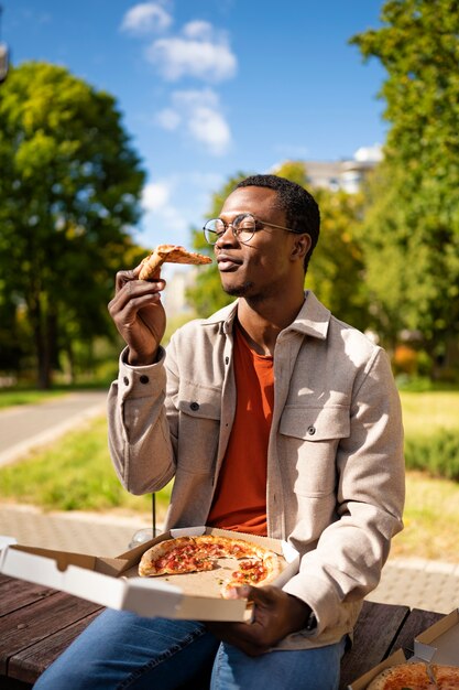 Lifestyle of friends eating pizzas outdoors