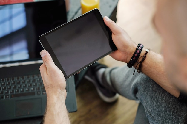 ライフスタイル。自宅でタブレットを持つ男