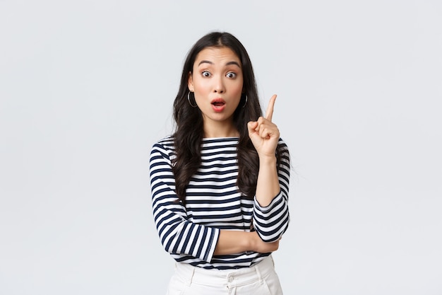 Lifestyle, people emotions and casual concept. Excited smart and creative asian female coworker have suggestion, add idea, raising index finger to say thought or plan, standing white background.