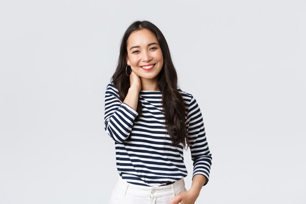 Lifestyle, people emotions and casual concept. Joyful beautiful asian woman in stylish casual clothes, touch neck blushing and smiling, having small talk at romantic date