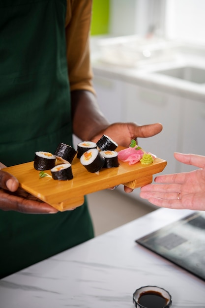Free photo lifestyle: people learning to make sushi